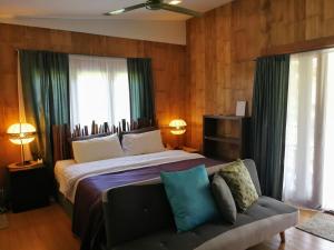 Ban Khanong Phra Klang (1)的住宿－考艾布魯克賓館，一间卧室配有一张大床和一张沙发