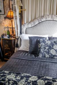 a bedroom with a blue and white bed and a lamp at Jeakes House in Rye