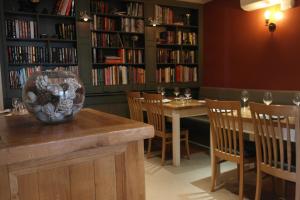 a restaurant with two tables and chairs and bookshelves at The North Hill Hotel in Colchester