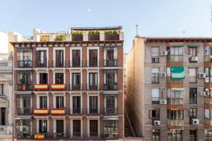 マドリードにあるEn Palacio Casa Entera con Dos Suitesのバルコニー付きの高層ビル