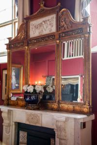 a large mirror sitting on top of a fireplace at Jeakes House in Rye