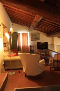 a living room with a couch and a chair at Il Fico in Chianti in Gaiole in Chianti