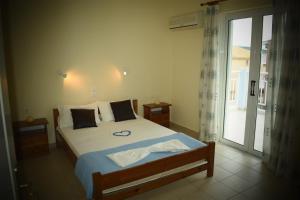 a bedroom with a bed and a sliding glass door at Parashis Studios in Alykes