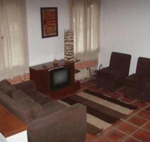 a living room with a couch and a television at Cerro de la Cruz in Cafayate +18 photos
