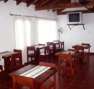 a dining room with wooden tables and chairs and a tv at Cerro de la Cruz in Cafayate