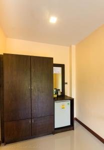 een keuken met een houten kast en een koelkast bij Toongyoong Longbeach Resort SHA Plus in Koh Lanta