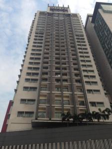 un grand bâtiment avec des arbres devant lui dans l'établissement Taragon Putrie Bintang suites, à Kuala Lumpur