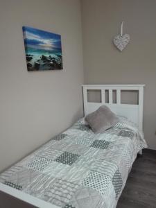 1 dormitorio blanco con 1 cama y una foto en la pared en Camarotes 17 y 28, en Las Palmas de Gran Canaria