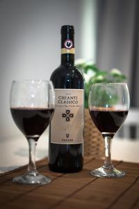 uma garrafa de vinho ao lado de dois copos de vinho tinto em Laura Family Apartments em Roma