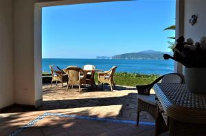 a patio with a table and chairs and the ocean at Villa Tiziana in Casa Morcone