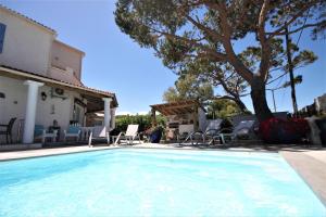 a large swimming pool with chairs and a house at Appart Bleu Azur in Saint-Florent