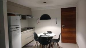 a kitchen with a table and chairs and a refrigerator at Apartamento mobiliado intermares in Cabedelo