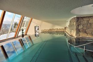 een zwembad in een gebouw met een rotswand bij Albtalblick Ihr Wellness- & Wanderhotel in Häusern