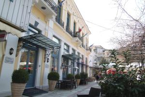 una calle de la ciudad con mesas, sillas y edificios en Hotel Panellinion, en Tríkala