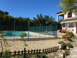 a swimming pool with a fence next to a house at B&B Sita chambres d'hotes in Saint-Cyr-sur-Mer