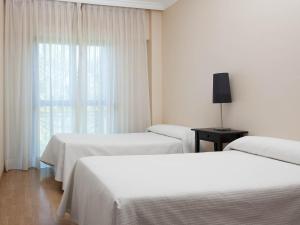 Łóżko lub łóżka w pokoju w obiekcie Apartamentos TH La Florida