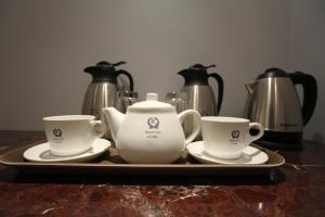 哈伊勒的住宿－黑爾洛姆旅館，盘子里放两个茶壶和两个杯子
