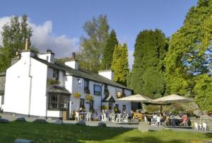a white building with people sitting outside of it at The Britannia Inn in Elterwater