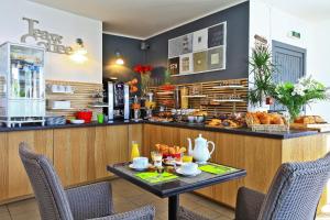 a cafe with a table and a counter with food at La Chaize - Villa, Suites & Spa in Noirmoutier-en-l'lle