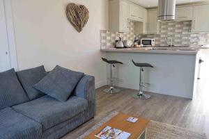 a living room with a couch and a kitchen at Little Fernleigh in Perranporth