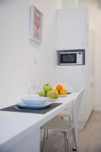 
a white table topped with a white plate topped with a bowl of fruit at Barcode Apartments Zrinjevac in Zagreb

