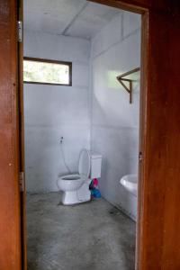 a white bathroom with a toilet and a sink at Innthar Lodge Home Stay in Ywama