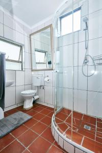 La salle de bains est pourvue de toilettes et d'une douche en verre. dans l'établissement 1202 on Cowgill, à Pretoria