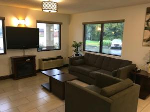a living room with a couch and a flat screen tv at GuestHouse Inn Dothan in Dothan