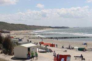 a group of people on a beach near the ocean at Zon Zee Zoutelande in Zoutelande