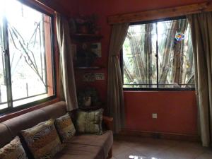 a living room with a couch and two windows at Lake View Studios in Nairobi