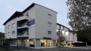 a large white building with a store front at Mercure Hotel Forbach Centre de Loisirs in Forbach
