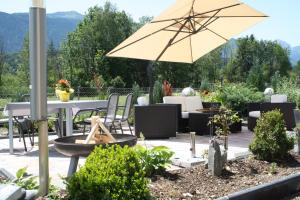 a patio with a table and an umbrella at Berglust Und Seenliebe in Presseggersee