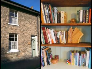 a book shelf filled with books next to a house at Milliner's Cottage in York
