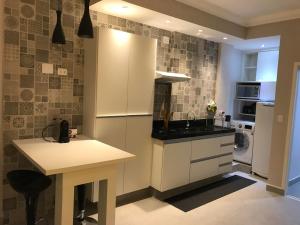 a kitchen with white cabinets and a counter top at Loft at Paulista Avenue (no coração de S.Paulo) in São Paulo