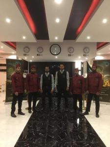 a group of men standing in a room with clocks at Desert Rose in Hail