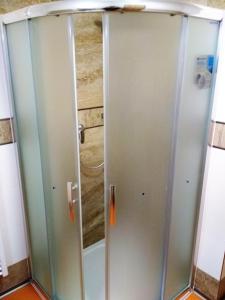 a shower with a glass door in a bathroom at Penzion Pod Kaštany Kvasice in Kvasice