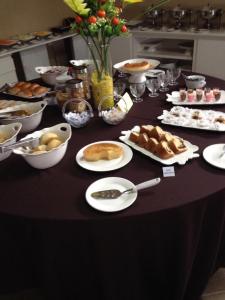 a table with plates of food on a table at Lacazzona Hotel in Belo Jardim