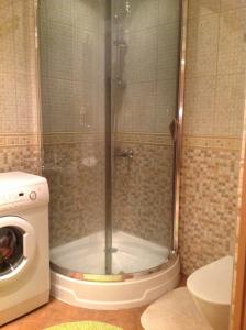 y baño con ducha y lavadora. en Poska Apartment, en Narva-Jõesuu