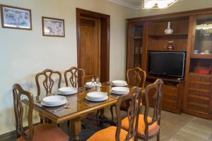 a dining room with a table with chairs and a television at Casa Ruano in Córdoba