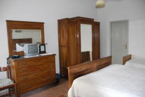 um quarto com uma cama e uma cómoda com uma televisão em B&B Cascina Bricchetto em Asti