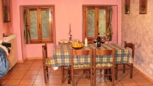 a dining room with a table and some windows at Case Danti Padronale in Santa Fiora