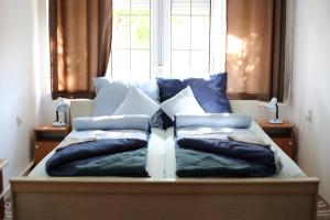 una cama con almohadas frente a una ventana en Hív-Lak Apartman en Eger