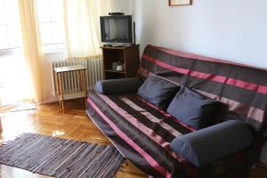 埃格爾的住宿－Hív-Lak Apartman，客厅里一张带毯子的沙发