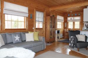 a living room with a couch and a kitchen at Lovely Cottage by Ounasjoki in Marraskoski
