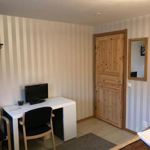 a room with a desk with a computer and a door at Hedemora Logi in Hedemora