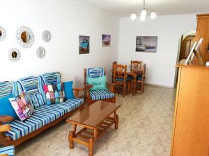 グラン・タラハルにあるApartamento Playa Gran Tarajalのリビングルーム(ソファ、椅子、テーブル付)