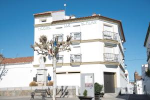 un edificio blanco con un árbol delante en Hostal DP El Pilar en Monesterio