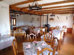 un comedor con mesas y sillas en una habitación en El Esguízaro, en Berzosa del Lozoya