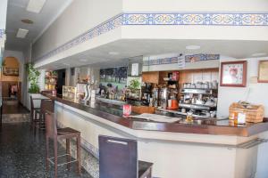 a restaurant with a bar with stools at Hostal DP El Pilar in Monesterio +13 photos