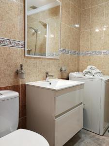 グラン・タラハルにあるApartamento Playa Gran Tarajalのバスルーム(洗面台、トイレ、鏡付)